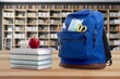 school backpack with stationery on table in labrary