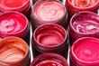 A lot of different lip balms in the jars, front view. Beauty concept.