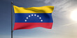 Venezuela national flag cloth fabric waving on beautiful grey sky Background.