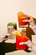 © ADDICTIVE STOCK - Anonymous trio of Refreshing Cocktails Held by Friends