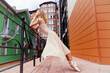ballerina on pointe shoes poses on a summer day on the street at the railing showing elements of ballet