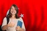 Fototapeta  - Attractive woman student showing thumb up against Turkish flag background. Travel, education and learn language in Türkiye concept