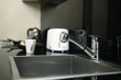 Stainless steel kitchen sink and tap water in modern kitchen