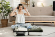 beautiful young woman happy Wear headphones to listen to music while packing your suitcase.