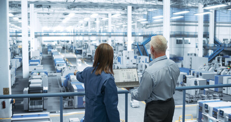 Aufkleber - Experienced Male and Female Engineers Standing on a Platform, Using Laptop Computer and Discussing Production at a Modern Automated Electronics Manufacture with AI Support