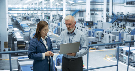 Fototapete - Experienced Middle Aged Engineer Giving an Electronics Factory Tour to Young Japanese Student. Asian Female with Technical Background Asking Questions About Production, Manufacturing, Research