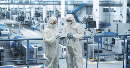 Aufkleber - Two Female Technicians in Protective Coveralls Having a Conversation and Using Tablet Computer. Specialists Monitoring, Analyzing Conditions at a Modern Electronics Factory with Automated Robots