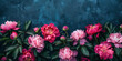 A captivating display of pink peonies flourishing against a richly textured indigo backdrop, offering a blend of natural beauty and artistic expression. Top view with copy space.