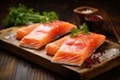 Salmon fillet cut into portions on ice on a wooden board
