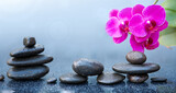 Fototapeta Panele - Pink orchid flowers and black spa stones on the gray table background.