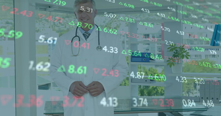 Wall Mural - Image of stock market data processing over caucasian male doctor smiling at hospital