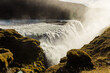 Sun-kissed Gullfoss waterfall in Iceland amidst lush greenery an