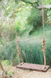 Rustic wooden swing hanging in a tranquil forest