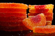 Close-Up of Sugary Orange Fruit Slices Against Black Background