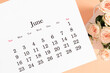 Flat lay of June 2024 paper desk calendar, top view. White beautiful roses on a light beige background.