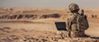 © Антон Сальников - An American soldier uses a laptop computer and radio to communicate in the desert during a military operation.