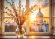 Palm Sunday. A close-up of a willow bouquet in a glass vase against the background of an ancient white window with a view of the golden domes of the temple and the setting sun.