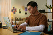 © DragonImages - High school student programming on laptop at home