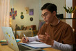 © DragonImages - Portrait of high school student having video call with tutor