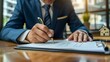 © DWN Media - Businessman in a suit signing a real estate contract in the style of the real estate agent.