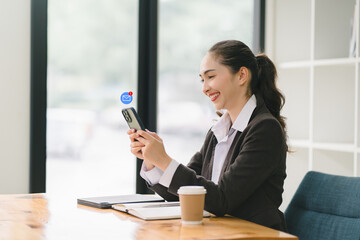 Smiling businesswoman using smartphone and show technology icon social media in modern office during coffee break.