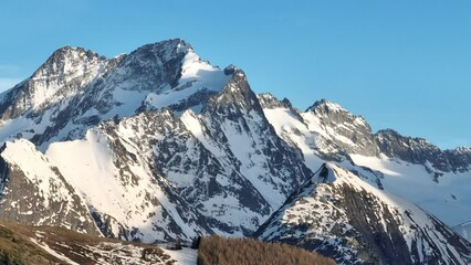 Wall Mural - Town in the alps mountains during sunset. Aerial drone photo. French alps in winter,  Rhone Alpes in France Europe . Les deux alpes village in spring time. Winter French Alpes town  from drone.