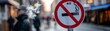 A close up of a no smoking sign with a blurred street scene in the background