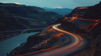 Poster - Trailing lights of cars winding along a mountain road during the dim hours of dusk