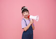 Asian little girl standing and holding megaphone isolated on pink background, Speech and announce concept