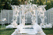 Outdoor wedding photo zone decorated with flowers.