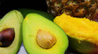 tropical fruits with avocado with seeds mango with juicy pulp and pineapple in the background
