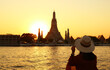 Woman Being Impressed with the Gorgeous Sunset View of Wat Arun or the Temple of Dawn, One of the Best Known Landmarks of Thailand