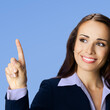 Young brunette woman businesswoman wear black confident suit, advertising showing pointing finger, typing. Business ad concept. Isolated against blue background. Square image.