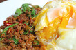 Closeup of Fried Egg Topped on Thai Style Stirred-fried Minced Beef and Holy Basil with Rice Called Kao Pad Kaprao Neua 
