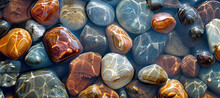 Smooth Multi-colored Pebbles Are Visible Under Clear Water.