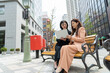 © taka - パソコンを見て電話す2人の女性
