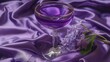   A tight shot of a wine glass atop a purple fabric, featuring a solitary purple blossom in its center