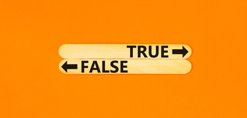 Wall Mural - True or false symbol. Concept word True or False on beautiful wooden stick. Beautiful orange table orange background. Business and true or false concept. Copy space.