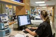 © EvgeniiaFreeman - Female Nurse Working at Computer Station in Hospital Corridor