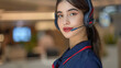 A woman wearing a headset stands in front of a wall. She is smiling and she is happy. professional female travel agent whit telephonic headphone. elegant and confident woman for her customers