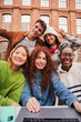 © Jose Calsina - Vertical portrait of a group of friends having fun and smiling together. High school students looking at camera with happy expression. Young friendly real people staring front posing for a photo