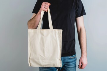 Wall Mural -   A man holds a white tote bag in his right hand and wears a black T-shirt
