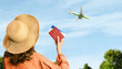 female tourist with tickets and passport in hands against the background of the sky and a landing plane
