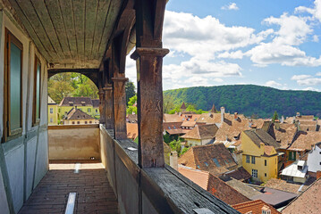 Wall Mural - Landscape from the top level of the Clock Tower in the Romanian city of Sighisoara: a fragment of the old wooden gallery and a breathtaking view of the buildings in the Old Town