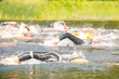 Participants swim into open water at the start of a triathlon on a lake