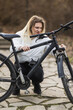 Woman Inspects Her Mountain Bike in a Park