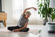 Active senior woman stretching and exercising indoors. Exercise for older adults