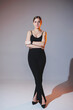 A young woman in a black top and black pants. Stylish woman in heels.