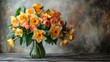  yellow and orange blooms in a clear vase, against a gray wall backdrop
