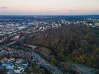 Wall Mural - Aerial cityscape with forest at sunset during fall and residential Pittsburgh Pennsylvania